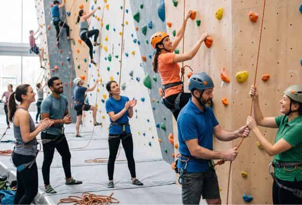 Colleghi che arrampicano in una palestra indoor durante un team building arrampicata