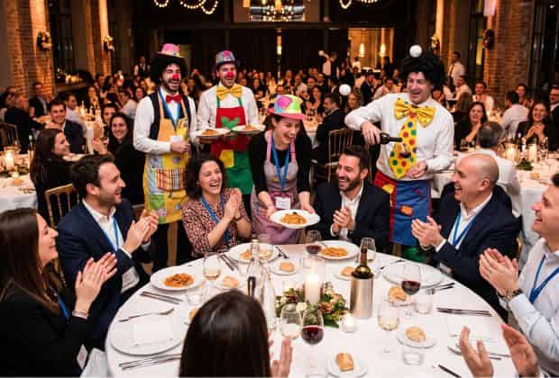 Camerieri che servono i propri colleghi in modo comico durante una cena aziendale