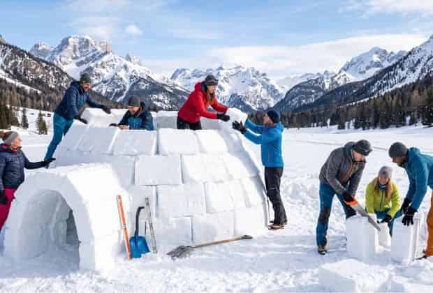 Un gruppo di colleghi che sta costruendo un igloo durante un team building