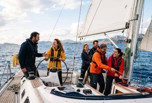 Colleghi che stanno collaborando per guidare una barca a vela