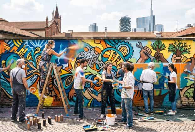 Colleghi che dipingono un muro durante un team building murales & graffiti street art