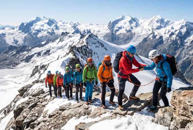 Colleghi in cordata per raggiungere la vetta di un 4000 durante un team building