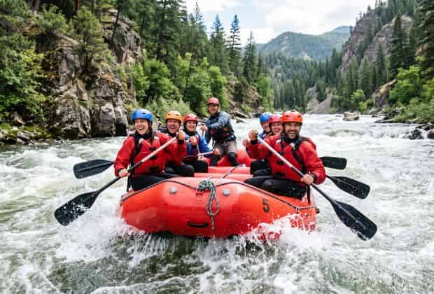 Colleghi che fanno un team building rafting su un fiume in montagna