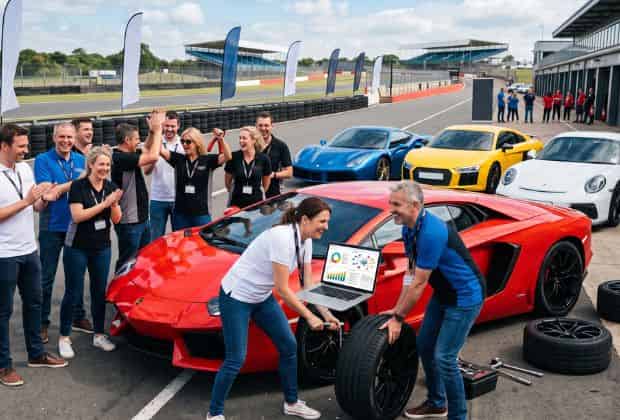 Colleghi che fanno il pit stop a una supercar durante un team building